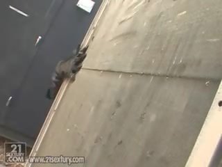 Dubļains vega ķildīga sieviete crouches par viņai catwoman kostīms uz the rooftop