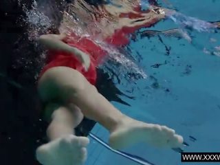 Provoserende brunette anna i rød kjole svømming