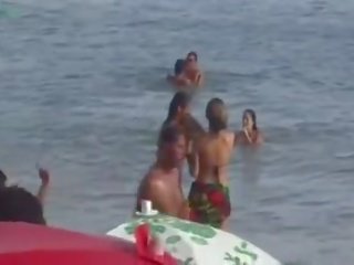 Casal trepando na praia.